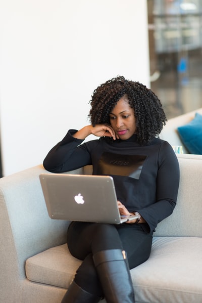 A woman in a black coat with the MacBook

